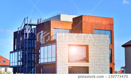 Office building facade covered in unique Corten steel, stones and glass materials. 130773470