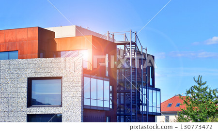Office building facade covered in unique Corten steel, stones and glass materials. 130773472