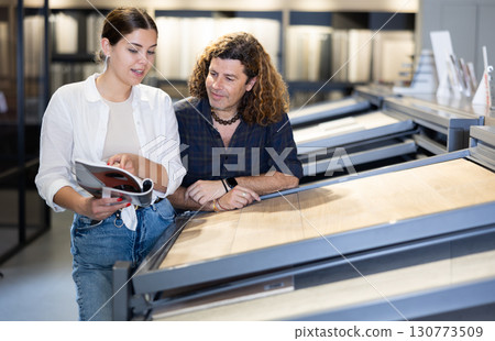 spouses carefully examine flooring wood material laminate 130773509