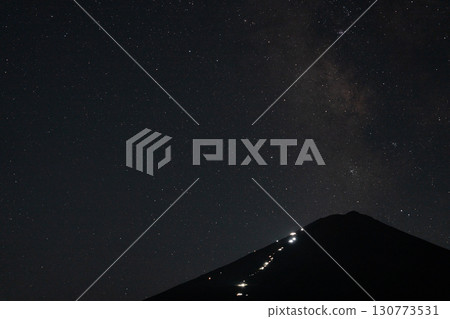 夏季的富士山,山間小屋的燈光亮起,銀河在夜空中蔓延 夏季的富士山,山間小屋的燈光亮起,銀河在夜空中蔓延 130773531