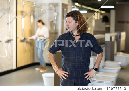Portrait of male customer making a choice in plumbing and building materials store Portrait of male customer making a choice in plumbing and building materials store 130773540