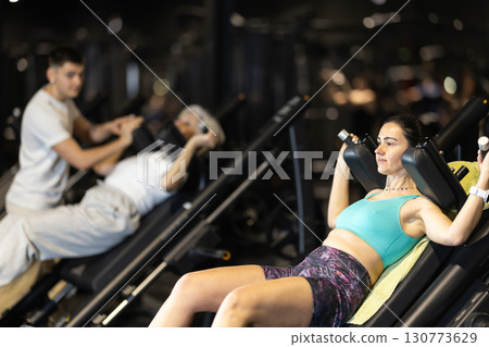 Woman performing hack squats in modern gym 130773629