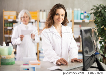 Female pharmacist using computer, companion at background 130773691