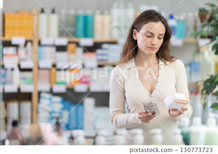 Woman choose pills in pharmacy 130773723