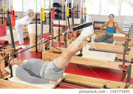 Adult man training her legs using straps 130773895