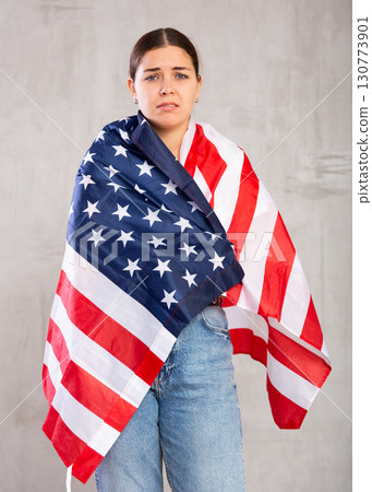 Sad young woman holding USA flag 130773901