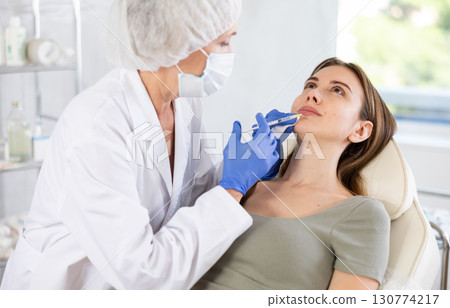 Young woman getting lip fillers. 130774217