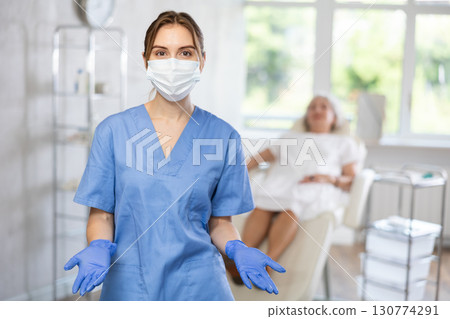 Portrait of young female doctor in scrub and mask. Portrait of young female doctor in scrub and mask. 130774291