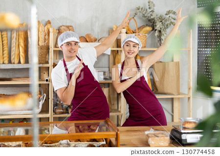 Woman and man sellers dance at counter in bakery 130774458