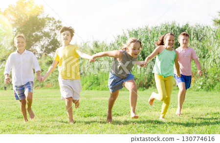 Children running on green grass 130774616