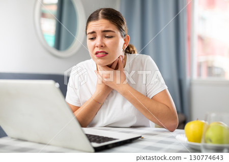 Young girl tells the doctor by video link that she has a sore throat Young girl tells the doctor by video link that she has a sore throat 130774643