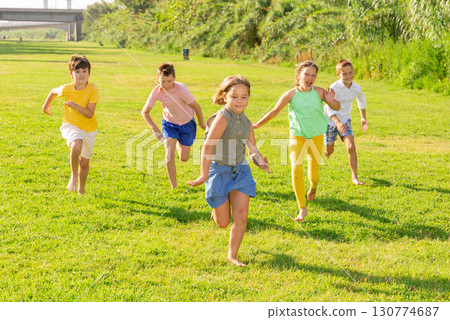 Barefoot kids running on green grass 130774687