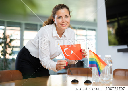 Young lady sets miniatures flags of LGBT and Turkey before international negotiations 130774707