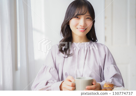 Young woman drinking a hot drink 130774737