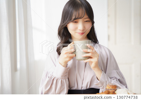 Young woman drinking a hot drink 130774738