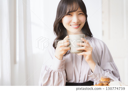 Young woman drinking a hot drink Young woman drinking a hot drink 130774739