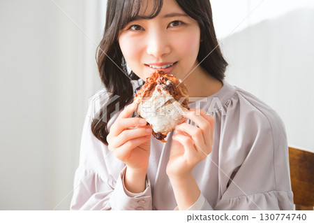 A young woman eating a muffin with relish A young woman eating a muffin with relish 130774740