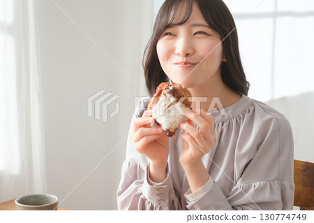 一位年輕女子津津有味地吃著鬆餅 一位年輕女子津津有味地吃著鬆餅 130774749