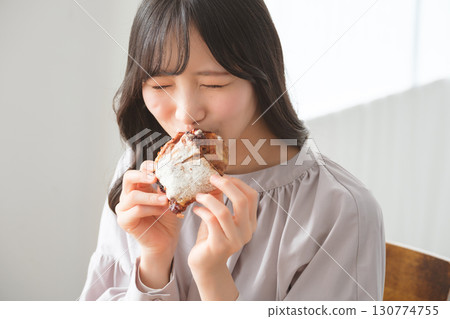 A young woman eating a muffin with relish A young woman eating a muffin with relish 130774755