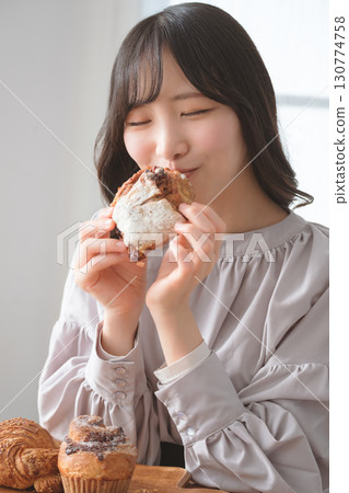 一位年輕女子津津有味地吃著鬆餅 一位年輕女子津津有味地吃著鬆餅 130774758