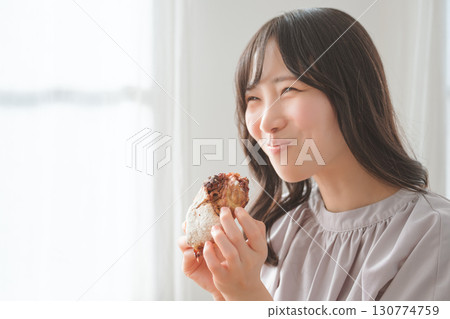 一位年輕女子津津有味地吃著鬆餅 130774759