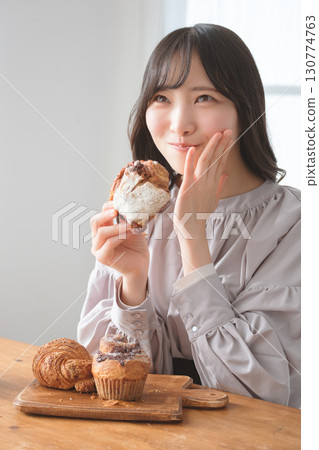 A young woman eating a muffin with relish A young woman eating a muffin with relish 130774763