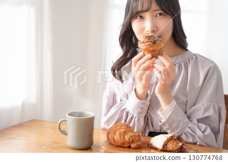 一位年輕女子津津有味地吃著鬆餅 130774768