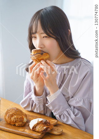 A young woman eating a muffin with relish A young woman eating a muffin with relish 130774780