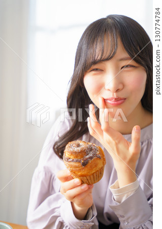 A young woman eating a muffin with relish A young woman eating a muffin with relish 130774784