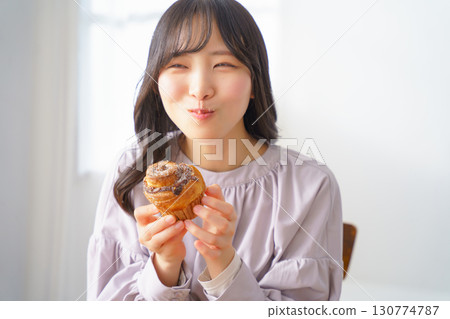 一位年輕女子津津有味地吃著鬆餅 130774787
