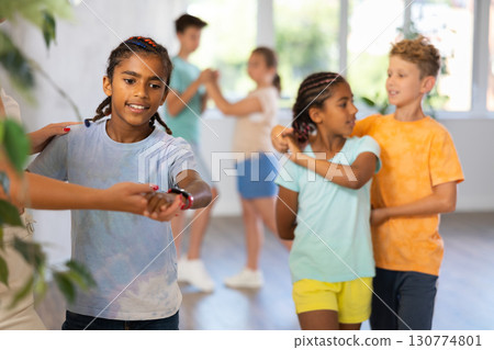 Cheerful preteen african american boy dancing with female instructor 130774801