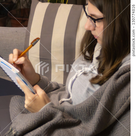 Close up of a teenage girl freelancer working from home in the living room 130774816