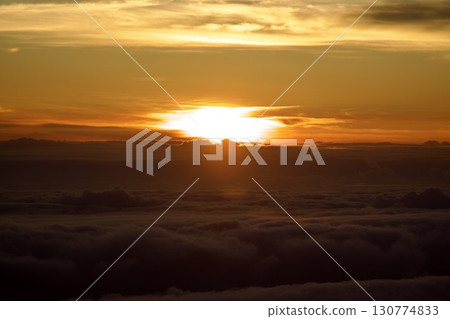 The morning sun rising from under the sea of clouds and the scenery of the morning glow The morning sun rising from under the sea of clouds and the scenery of the morning glow 130774833