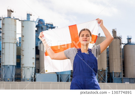 Sad young woman near factory with flag of England 130774891