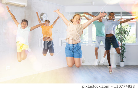 Children jumping while studying modern style dance in class indoors Children jumping while studying modern style dance in class indoors 130774928