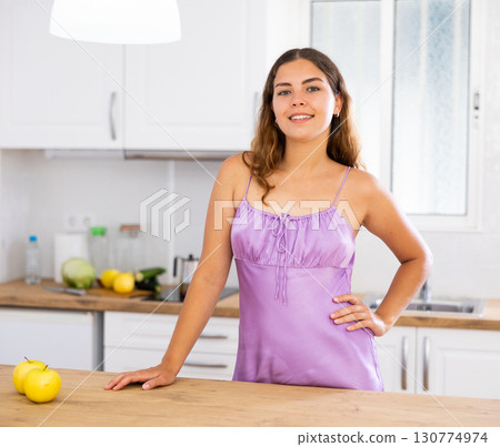 Young housewife in purple nightgown posing in kitchen Young housewife in purple nightgown posing in kitchen 130774974