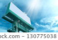 Advertising billboard on steel green structure.  Against the blue sky with clouds. Light shines from the sky. 130775038