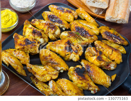 Picture of dish of tasty fried chicken wings served in black pan Picture of dish of tasty fried chicken wings served in black pan 130775163