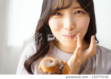 A young woman eating a muffin with relish A young woman eating a muffin with relish 130775436