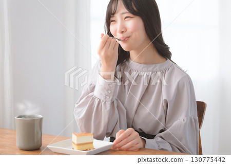 Young woman eating delicious cake Young woman eating delicious cake 130775442