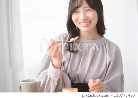 Young woman eating delicious cake 130775450