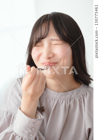 Young woman eating delicious cake 130775461
