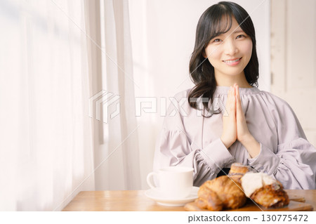 一名年輕女子說完「itadakimasu」後準備吃飯 一名年輕女子說完「itadakimasu」後準備吃飯 130775472
