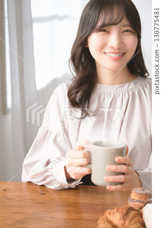 Young woman drinking a hot drink Young woman drinking a hot drink 130775481