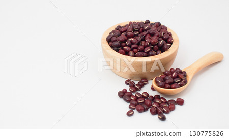 Red beans or adzuki beans in a wooden bowl and spoon with scattered seeds on a clean white background, representing nutrition, healthy food Red beans or adzuki beans in a wooden bowl and spoon with scattered seeds on a clean white background, representing nutrition, healthy food 130775826