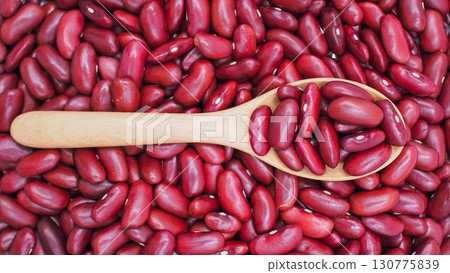 Close-up of red kidney beans in a wooden spoon with beans spread in the background, symbolizing healthy food, agriculture, and plant-based protein. Close-up of red kidney beans in a wooden spoon with beans spread in the background, symbolizing healthy food, agriculture, and plant-based protein. 130775839