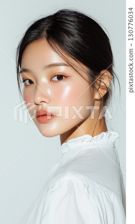 Young Korean woman with radiant skin poses gracefully against a light background during a photo shoot in a stylish outfit Young Korean woman with radiant skin poses gracefully against a light background during a photo shoot in a stylish outfit 130776034