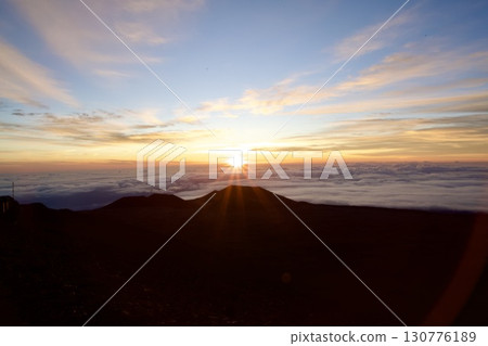 The glow of the morning sun rising from the sea of clouds The glow of the morning sun rising from the sea of clouds 130776189