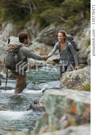 Friendship and Mutual Aid: Two Happy Friends On A Hiking Trip Hand-In-Hand, Showing Trust And Care In A Natural Setting. 130776471