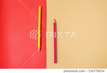 Red and yellow pencil on color background. 130776834